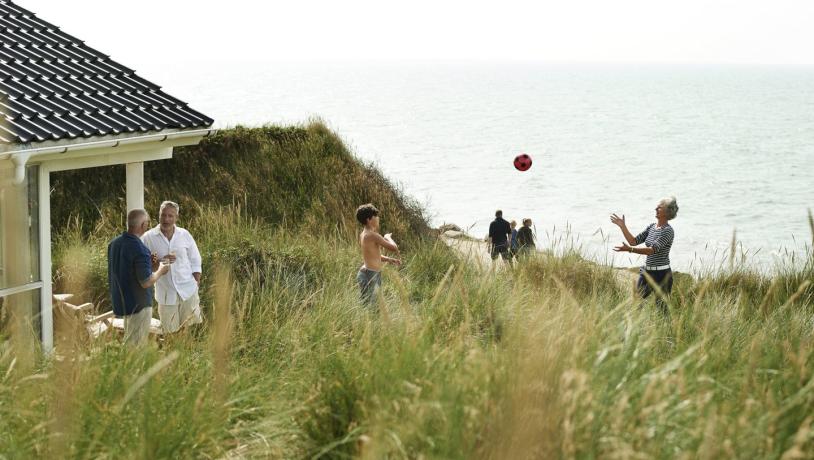 Family-Playing-Beach-Summerhouse