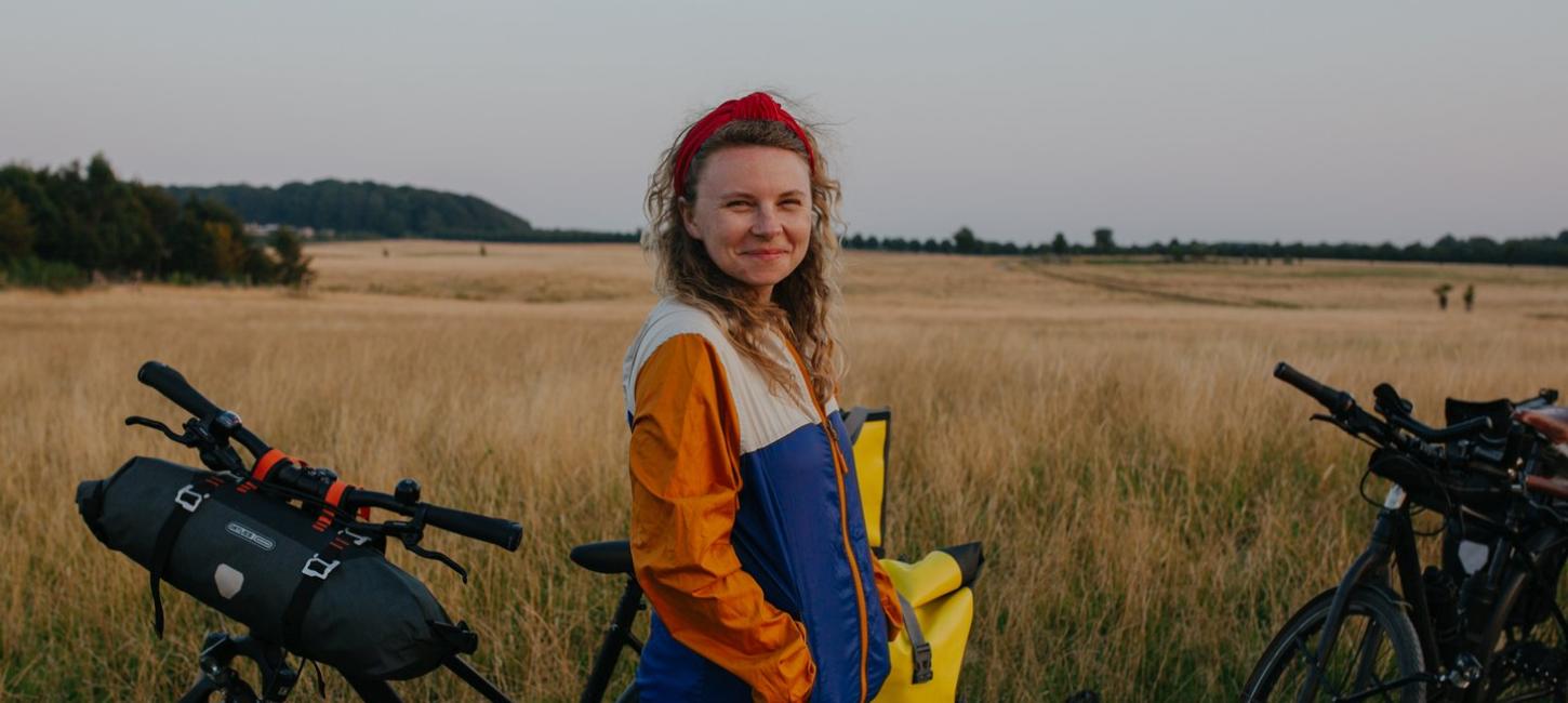 Woman with bikes on cycling trip at Naturparken Hindsgavl Dyrehave near Middelfart, Fyn