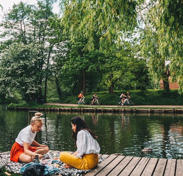 Freunde sitzen zusammen am Fluss Odense Å