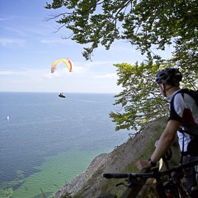 cyklist ser på paragliding ved Møns Klint