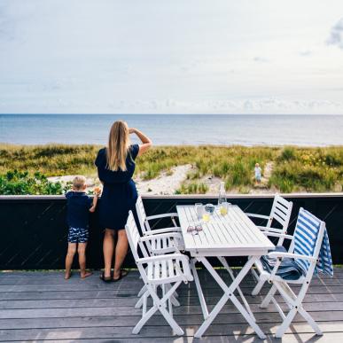 A mother and child looking at the water from a summer house on Djurland in East Jutland.