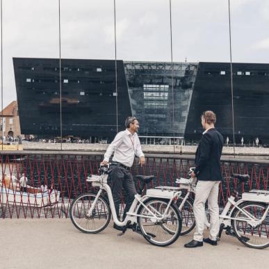 Business men with bikes talking on cirkelbroen in Copenhagen