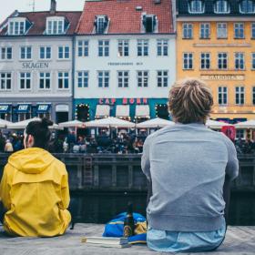 People sitting by the dock in Nyhavn, Copenhagen