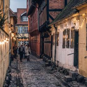 A cobbled street in Odense lit with Christmas lights